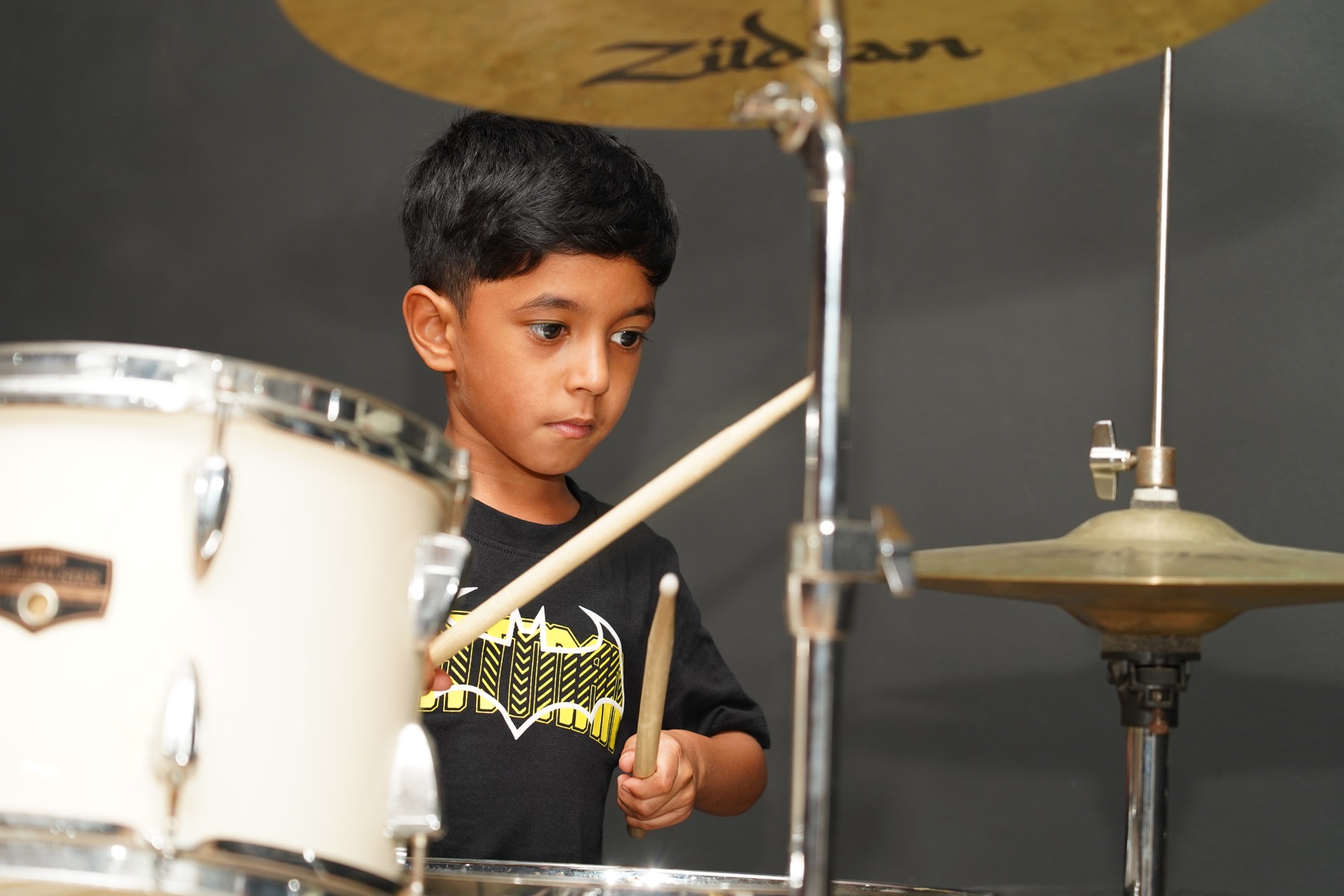 SARA Music School student concentrating while playing the drums